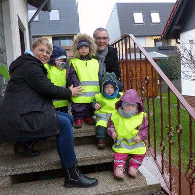 Auf dem Foto sieht man links Tagesmutter Sabine Eisenbrandt und rechts Vizelandrat Andreas Siebert sowie vier Tagespflegekinder mit den Warnwesten.